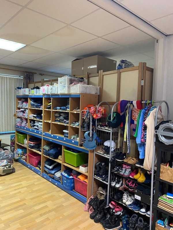 Stellingkast met beddengoed, handdoeken, keukenapparaten en huisraad.